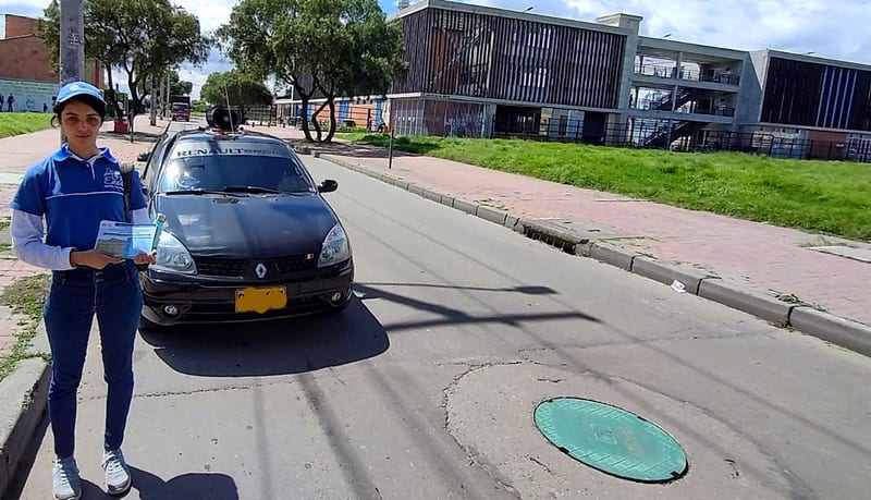 Impulsadora con volantes junto al carro de perifoneo en una calle de Bogotá